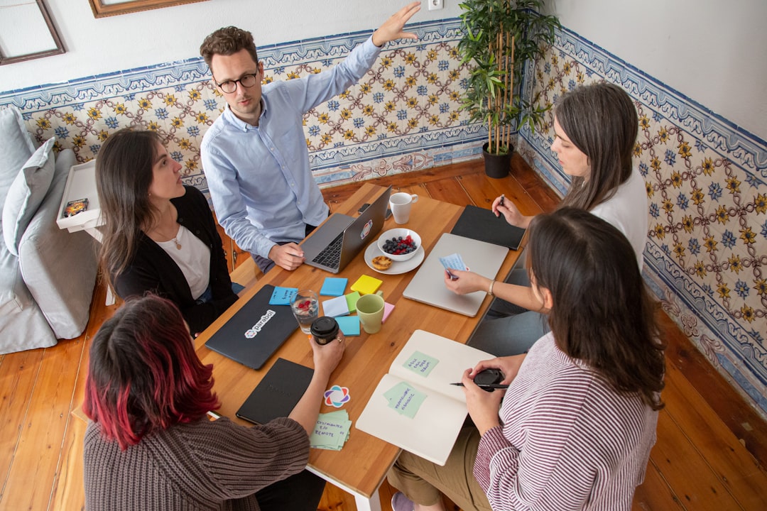 Colleagues discussing documents around a meeting table.