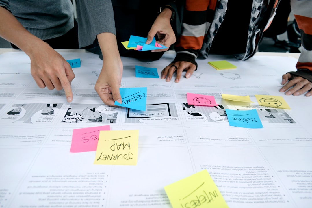 Hands arranging notes on a user journey map.