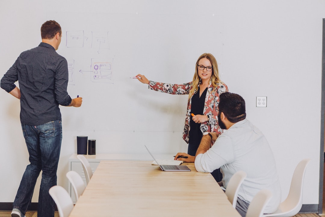 Colleagues discussing ideas beside a whiteboard.